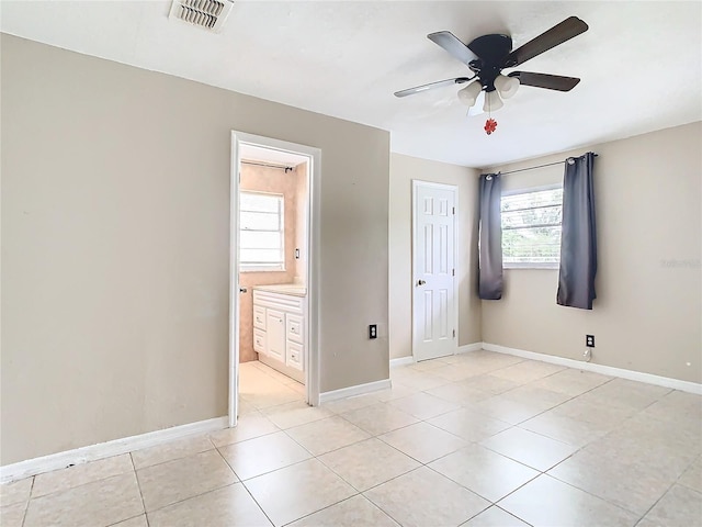 unfurnished bedroom featuring ceiling fan, connected bathroom, and light tile patterned floors