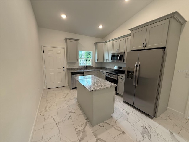 kitchen with sink, gray cabinets, a kitchen island, stainless steel appliances, and light stone countertops