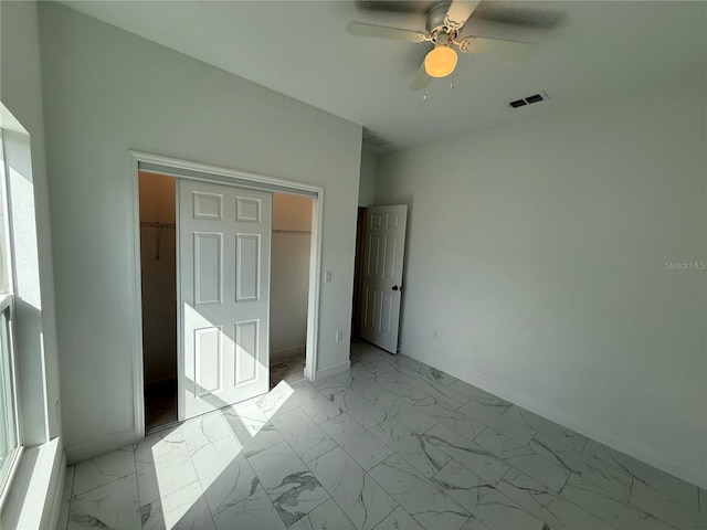 unfurnished bedroom with ceiling fan and a closet