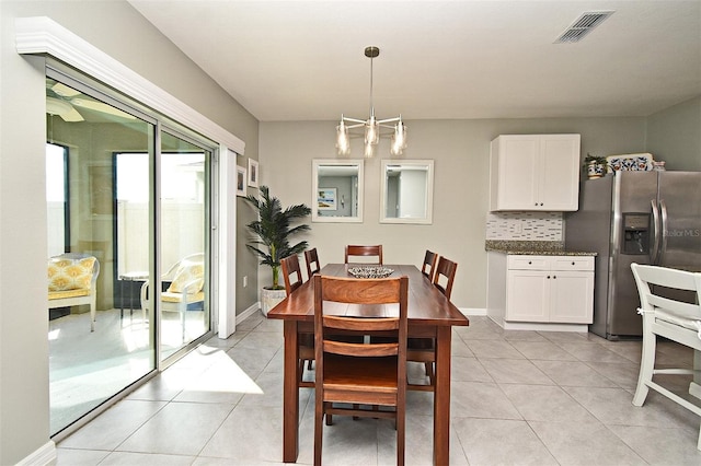 tiled dining space featuring an inviting chandelier