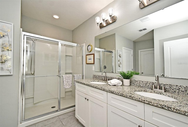 bathroom featuring tile patterned flooring, vanity, and walk in shower