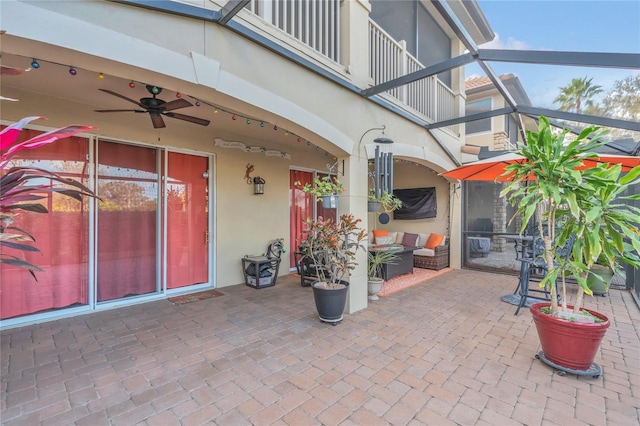 view of patio / terrace with a lanai, a balcony, and ceiling fan