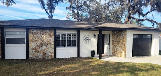 view of front of house featuring a garage, stone siding, a front yard, and stucco siding