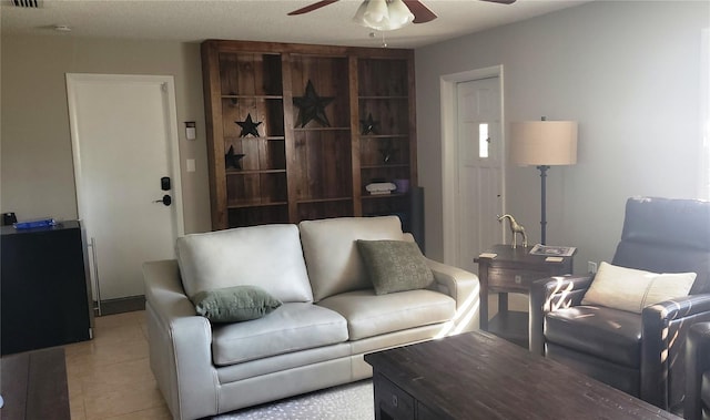 living area with light tile patterned floors, ceiling fan, and visible vents