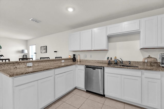 kitchen featuring dishwasher, a sink, and white cabinets