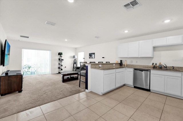 kitchen featuring open floor plan, light carpet, dishwasher, and white cabinetry