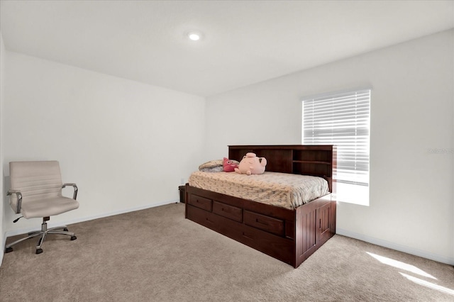 bedroom featuring light carpet and baseboards