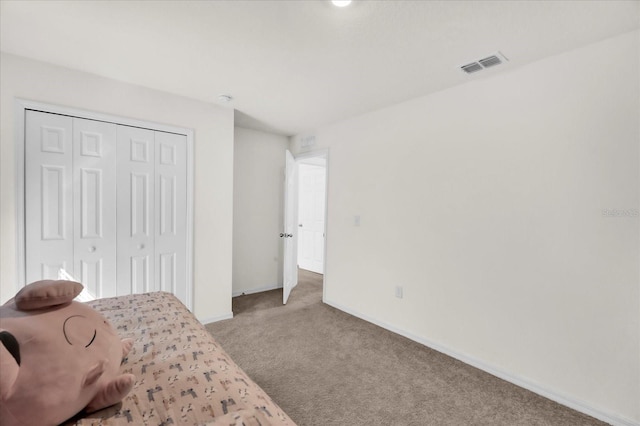 bedroom with light colored carpet, a closet, visible vents, and baseboards