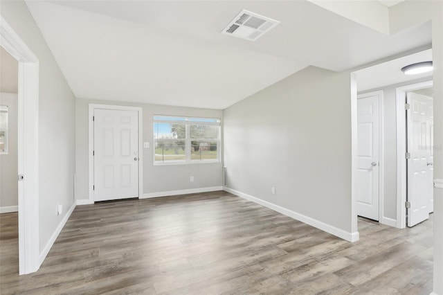 entrance foyer with lofted ceiling and light hardwood / wood-style floors