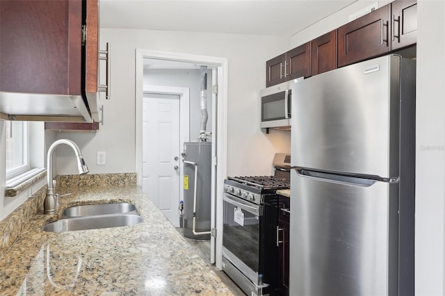 kitchen featuring sink, water heater, light stone countertops, and stainless steel appliances