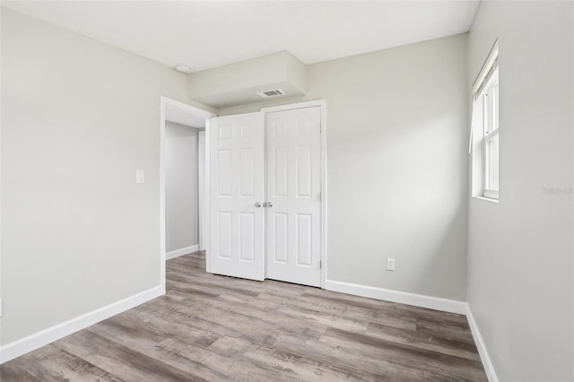 unfurnished bedroom featuring light hardwood / wood-style flooring and a closet