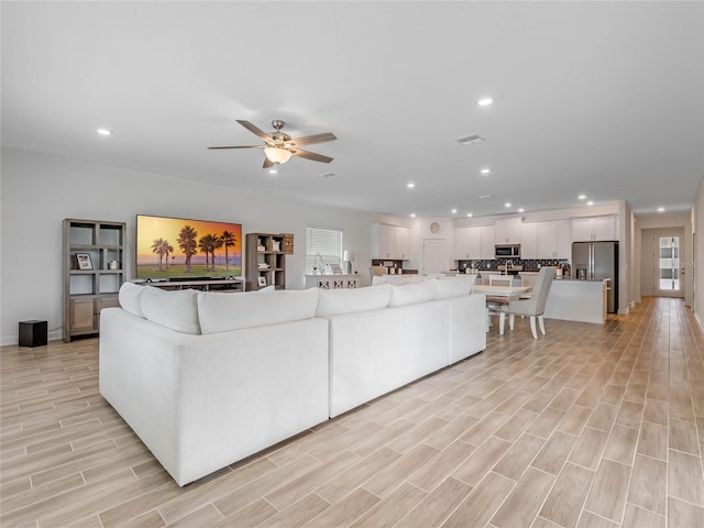 living room featuring light hardwood / wood-style floors and ceiling fan