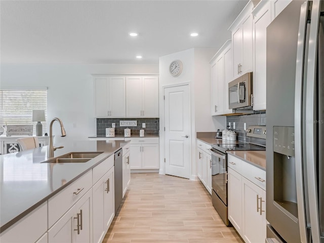 kitchen featuring tasteful backsplash, appliances with stainless steel finishes, sink, and white cabinets