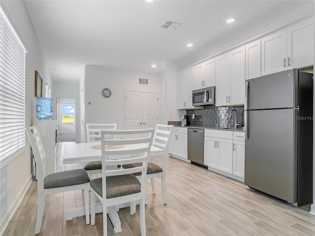 kitchen featuring white cabinetry, sink, decorative backsplash, and stainless steel appliances