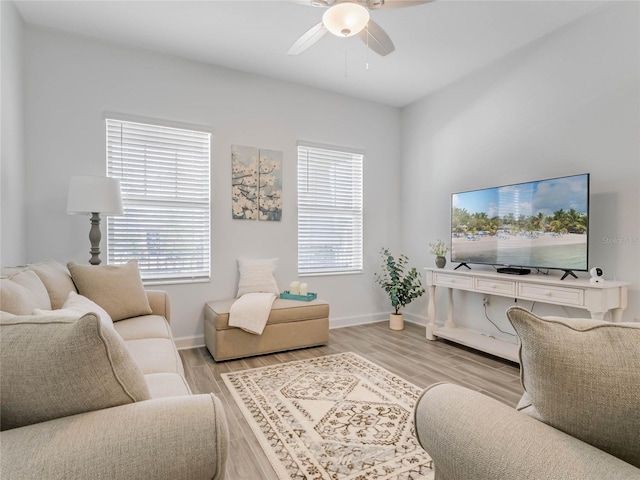 living room featuring ceiling fan, light hardwood / wood-style floors, and a healthy amount of sunlight