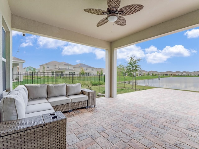 view of patio featuring a water view, ceiling fan, and outdoor lounge area