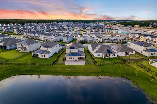 aerial view at dusk featuring a water view