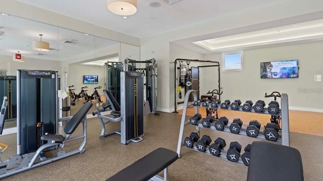 exercise room with a tray ceiling