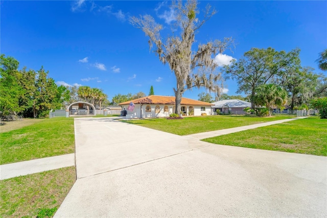 view of front facade with a gate, fence, concrete driveway, and a front yard