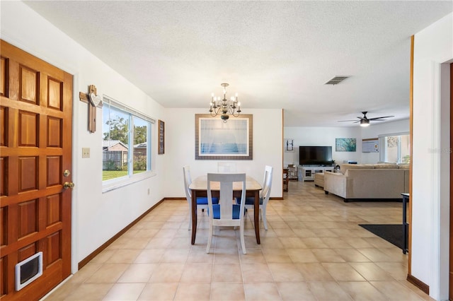 dining room with ceiling fan with notable chandelier and a textured ceiling