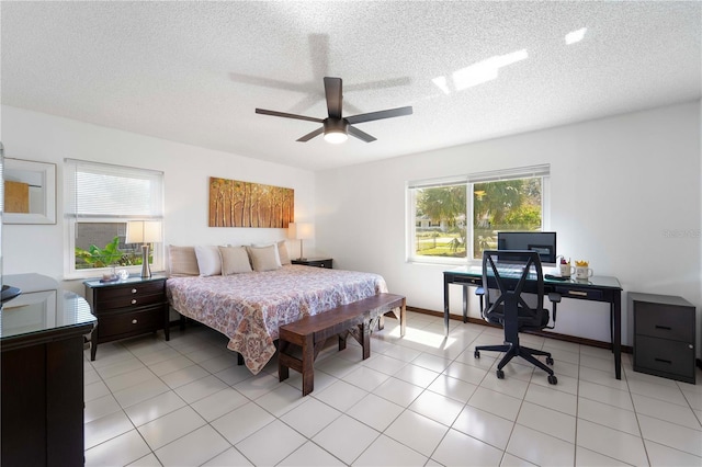 tiled bedroom with ceiling fan and a textured ceiling