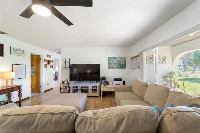 tiled living room featuring ceiling fan and a textured ceiling