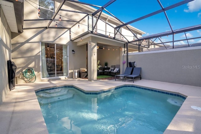 view of pool featuring glass enclosure and a patio area