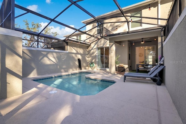 view of pool featuring glass enclosure and a patio