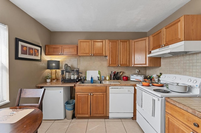 kitchen with sink, backsplash, white appliances, and light tile patterned floors