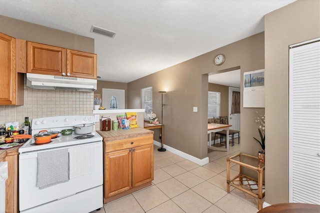 kitchen featuring tasteful backsplash, light tile patterned floors, and white range with electric cooktop