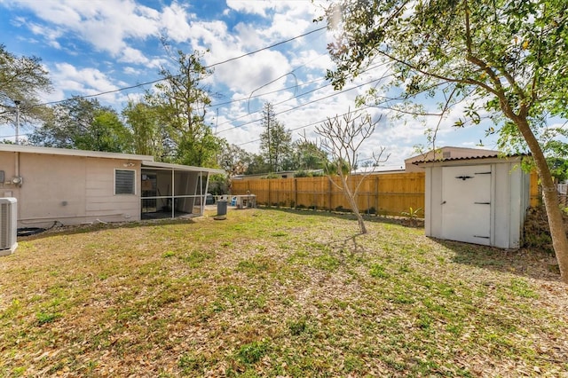 view of yard with a shed, central AC unit, and a sunroom