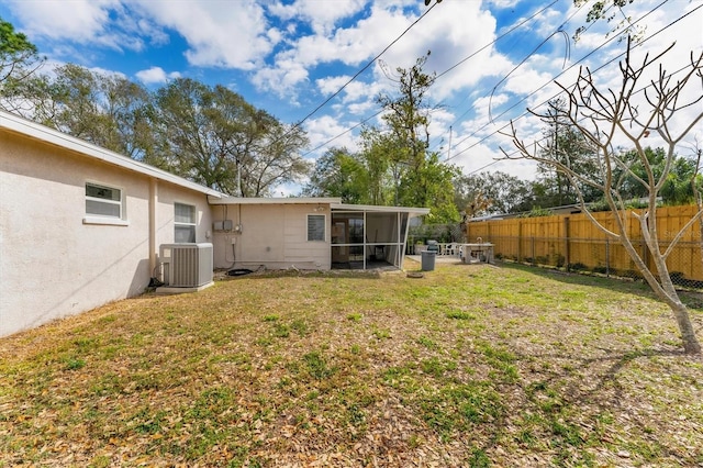 view of yard featuring a sunroom and central air condition unit