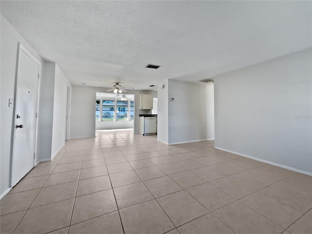 unfurnished living room with ceiling fan, a textured ceiling, and light tile patterned floors