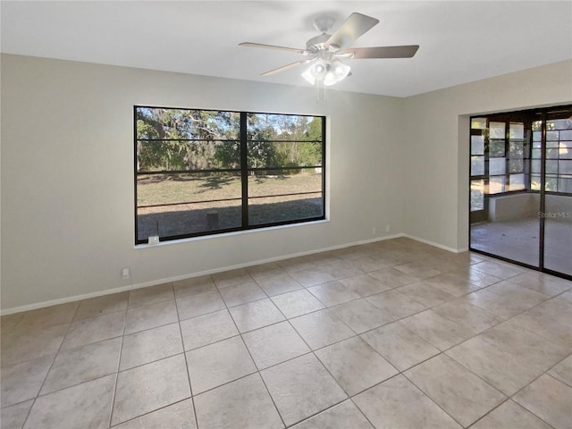 empty room with light tile patterned flooring, a wealth of natural light, and ceiling fan