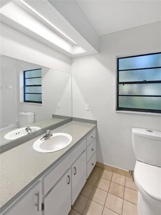 bathroom featuring toilet, tile patterned flooring, and vanity