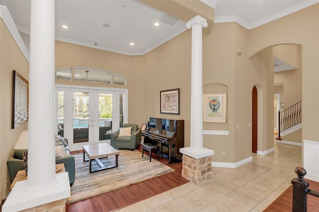 living area featuring crown molding, light tile patterned flooring, and ornate columns