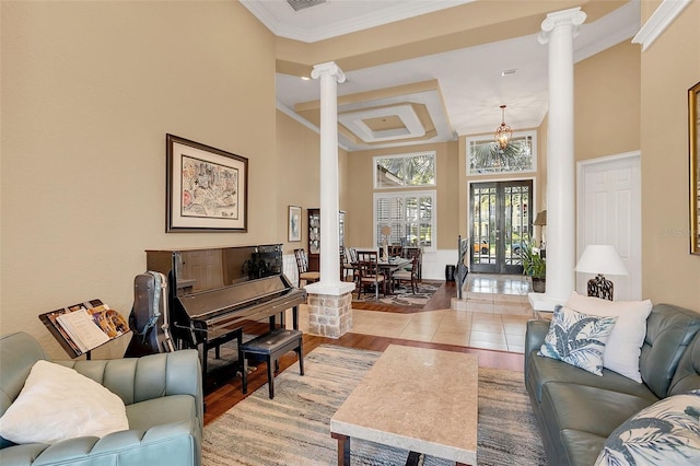 living room with light wood finished floors, french doors, ornamental molding, and decorative columns