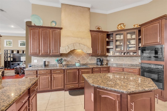 kitchen with black appliances, ornamental molding, and light stone counters