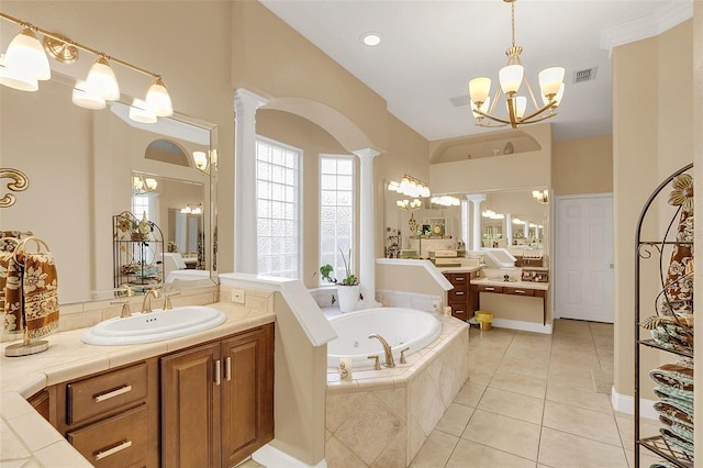 bathroom with a garden tub, a notable chandelier, decorative columns, a sink, and tile patterned flooring