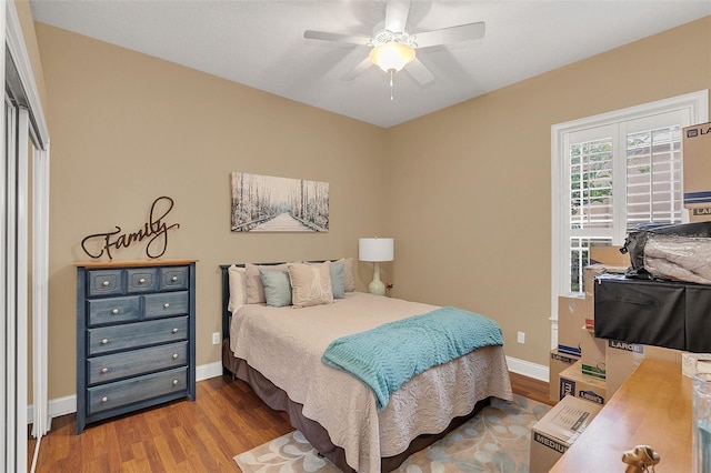 bedroom featuring ceiling fan, baseboards, and wood finished floors