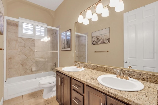 bathroom featuring toilet, double vanity, a sink, and tile patterned floors