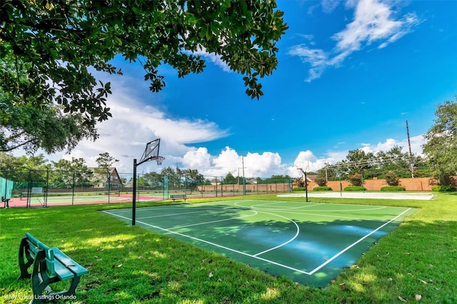 view of basketball court featuring community basketball court, fence, and a yard