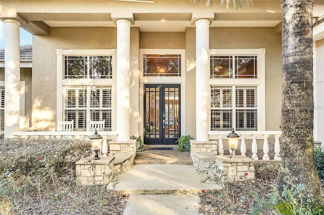 doorway to property featuring stucco siding and french doors