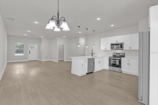 kitchen with sink, decorative light fixtures, stainless steel appliances, and kitchen peninsula