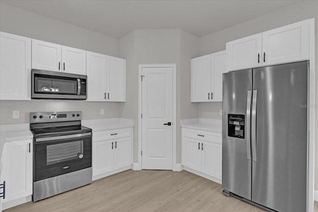 kitchen with stainless steel appliances, white cabinets, and light wood-type flooring