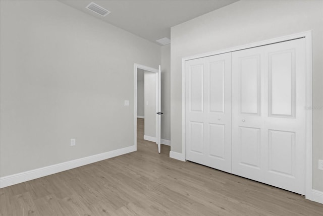 unfurnished bedroom with a closet and light wood-type flooring