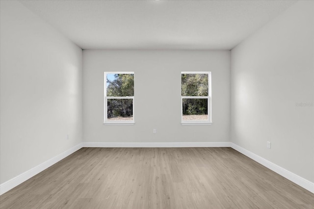 spare room featuring light hardwood / wood-style flooring and a wealth of natural light