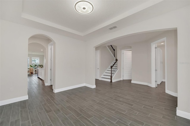 unfurnished room featuring a tray ceiling and a textured ceiling