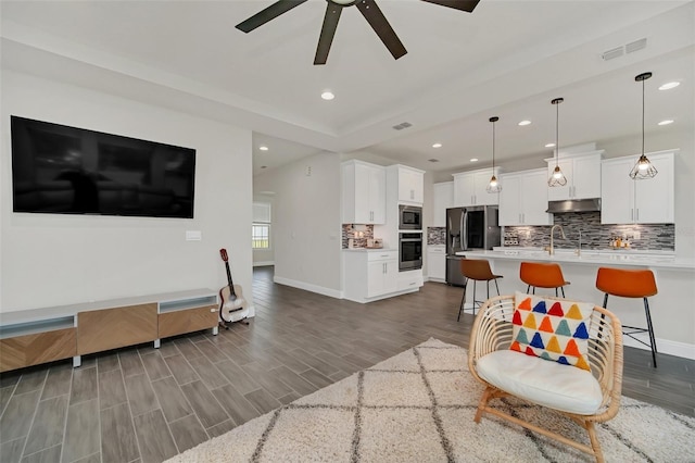 living room featuring sink and ceiling fan