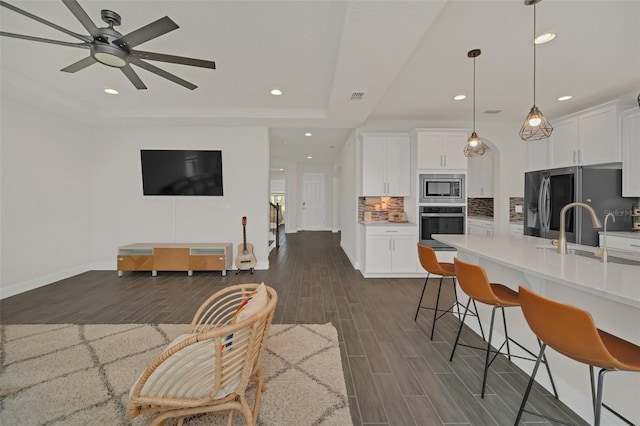 kitchen featuring pendant lighting, sink, stainless steel appliances, and white cabinets